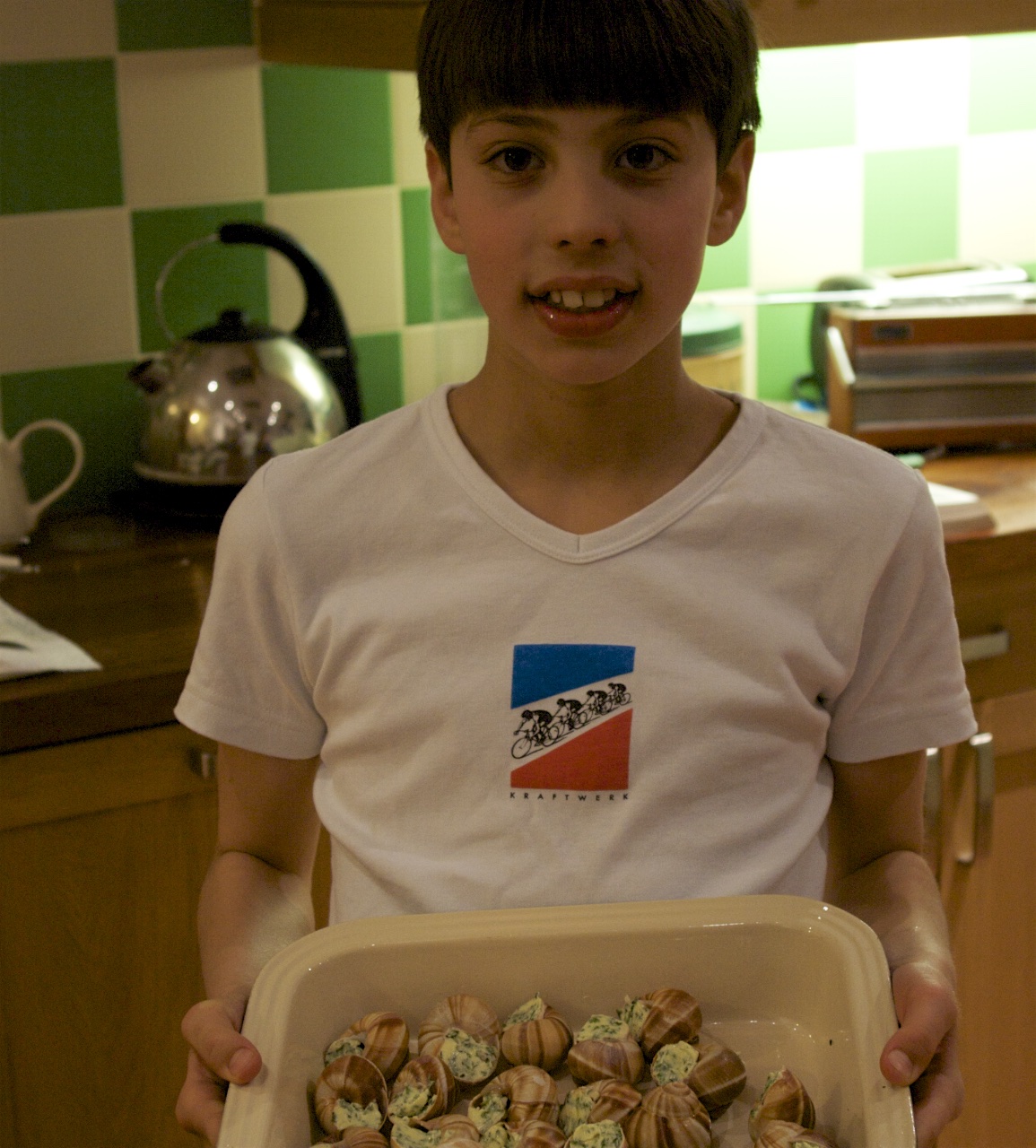 A child proudly showing a dish he has helped prepare